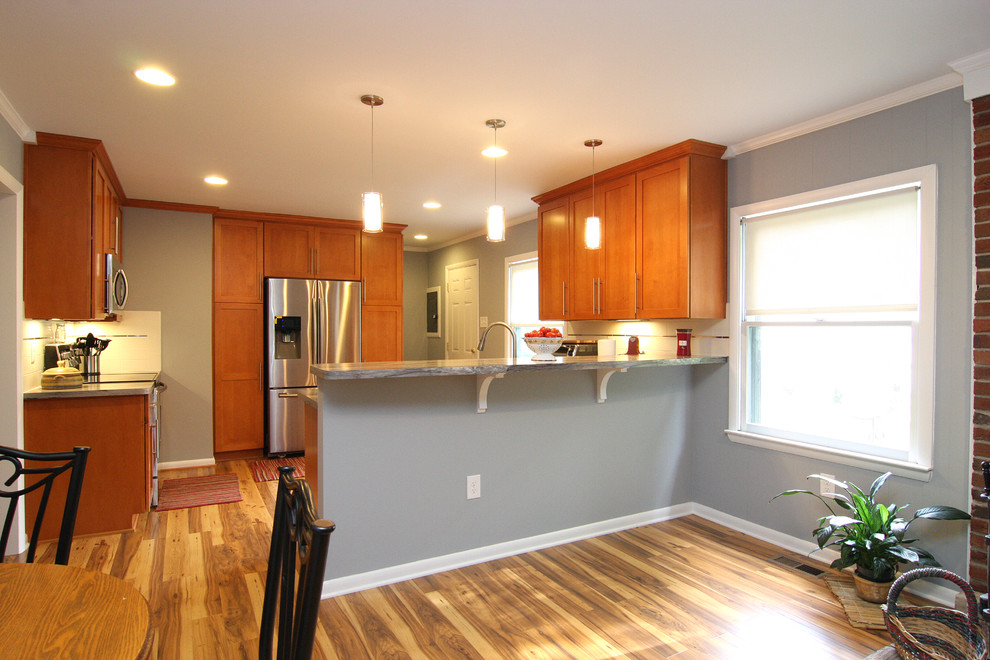 Inspiration for a large transitional u-shaped medium tone wood floor eat-in kitchen remodel with a drop-in sink, recessed-panel cabinets, medium tone wood cabinets, laminate countertops, white backsplash, ceramic backsplash, stainless steel appliances and a peninsula