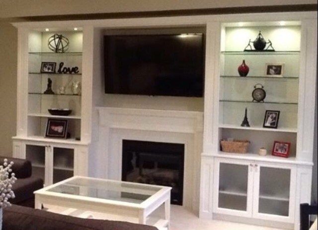 Photo of a mid-sized transitional living room in Toronto with beige walls, a standard fireplace, a wood fireplace surround and a built-in media wall.