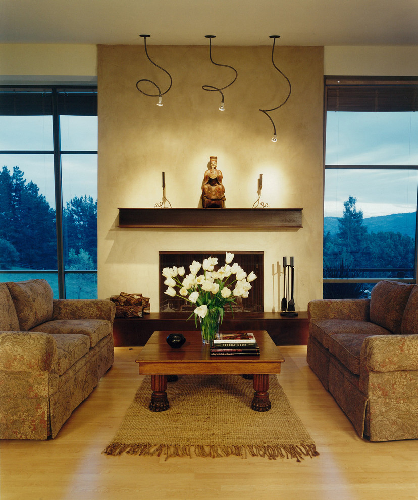 Photo of a country living room in San Francisco with beige walls, a standard fireplace and a plaster fireplace surround.