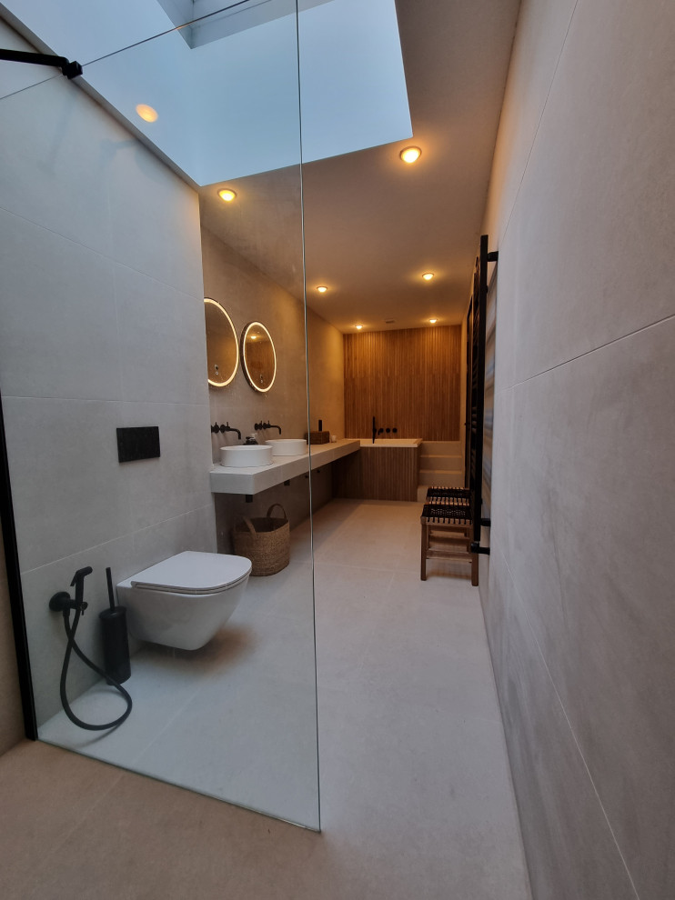 This is an example of a large scandi ensuite bathroom in Other with white cabinets, a japanese bath, a walk-in shower, a wall mounted toilet, white tiles, porcelain tiles, white walls, porcelain flooring, a vessel sink, tiled worktops, white floors, white worktops, a shower bench, double sinks and a floating vanity unit.