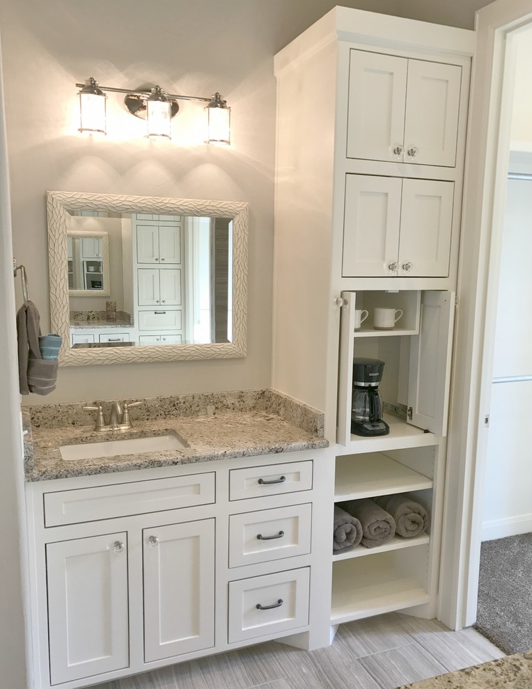 This is an example of a large country master bathroom in Dallas with recessed-panel cabinets, white cabinets, a drop-in tub, a corner shower, a one-piece toilet, multi-coloured tile, porcelain tile, grey walls, porcelain floors, an undermount sink, granite benchtops, multi-coloured floor and a hinged shower door.