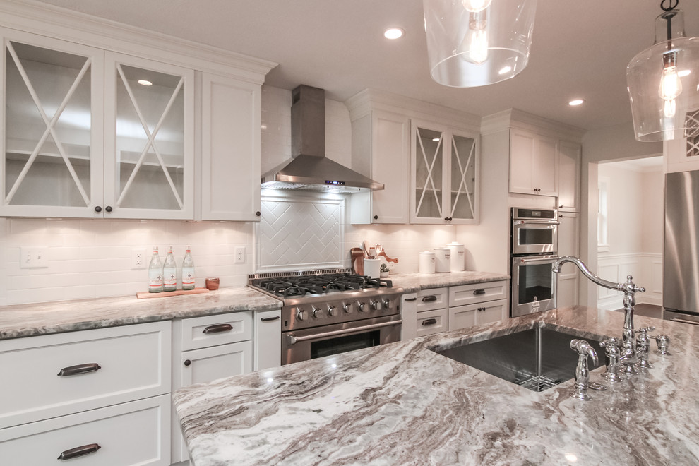 Inspiration for a mid-sized traditional l-shaped eat-in kitchen in Cleveland with a single-bowl sink, shaker cabinets, white cabinets, quartzite benchtops, white splashback, subway tile splashback, stainless steel appliances, bamboo floors, with island and brown floor.