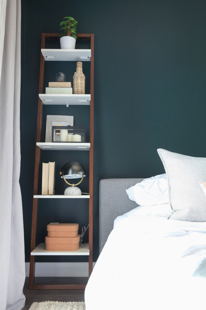 This is an example of a small eclectic master bedroom in Toronto with green walls, laminate floors and brown floor.