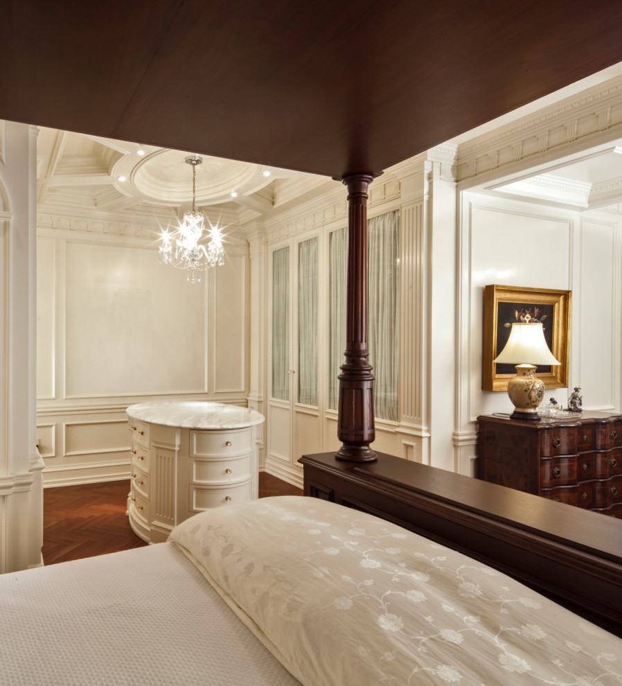 Ejemplo de dormitorio principal tradicional extra grande sin chimenea con paredes blancas, suelo de madera en tonos medios, suelo marrón, casetón y panelado