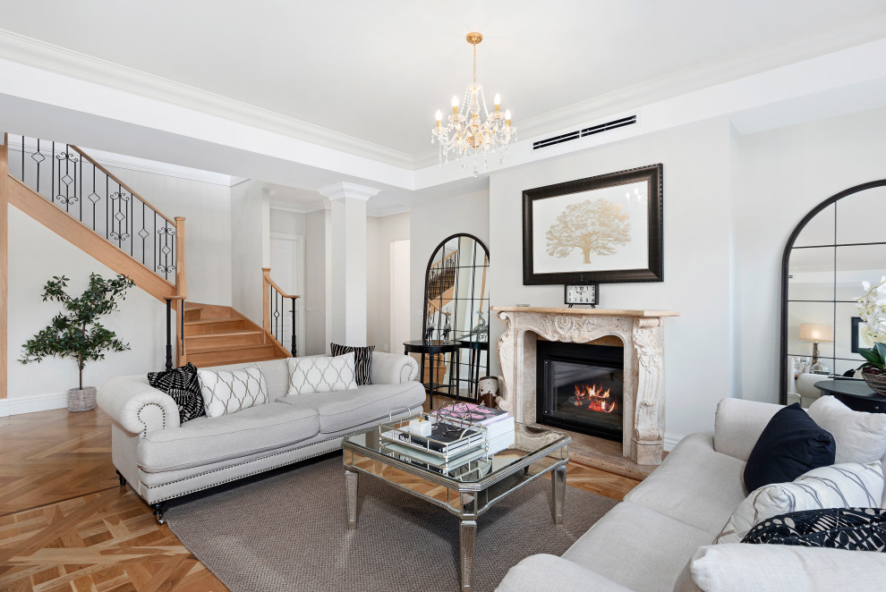 Inspiration for a mid-sized traditional open concept living room in Melbourne with beige walls, light hardwood floors, a standard fireplace, a stone fireplace surround, beige floor and recessed.