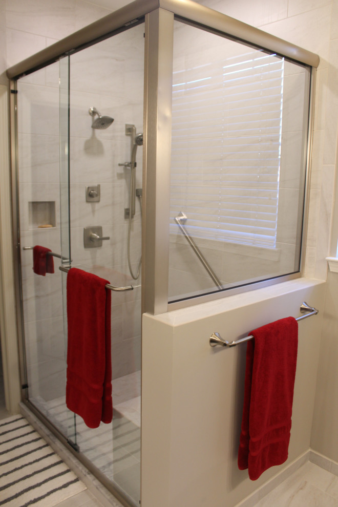 This is an example of a large transitional master bathroom in Detroit with raised-panel cabinets, medium wood cabinets, an open shower, white tile, ceramic tile, grey walls, porcelain floors, an undermount sink, engineered quartz benchtops, white floor, a sliding shower screen and white benchtops.
