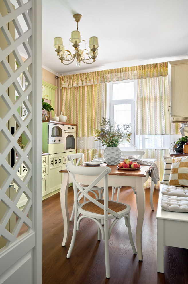 Mid-sized traditional single-wall eat-in kitchen in Moscow with recessed-panel cabinets, green cabinets, white appliances, dark hardwood floors, brown floor and white benchtop.