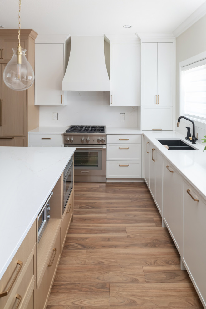 Kitchen - large u-shaped medium tone wood floor kitchen idea with an undermount sink, shaker cabinets, white cabinets, quartzite countertops, white backsplash, an island and white countertops