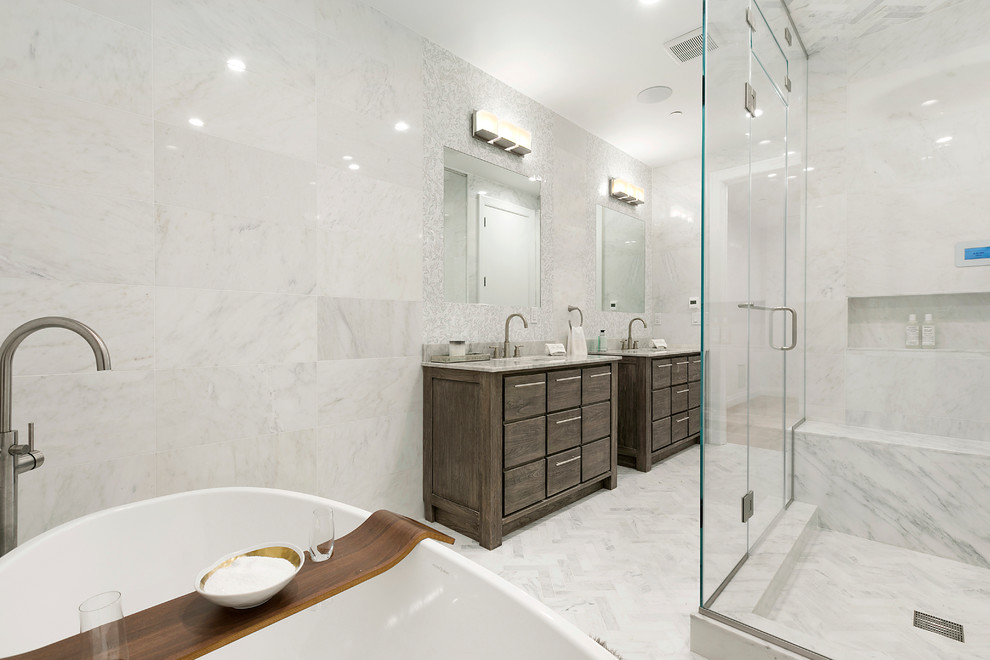 Photo of a transitional master bathroom in New York with flat-panel cabinets, dark wood cabinets, a freestanding tub, a corner shower, marble, grey walls, marble floors, an undermount sink, marble benchtops, grey floor and a hinged shower door.