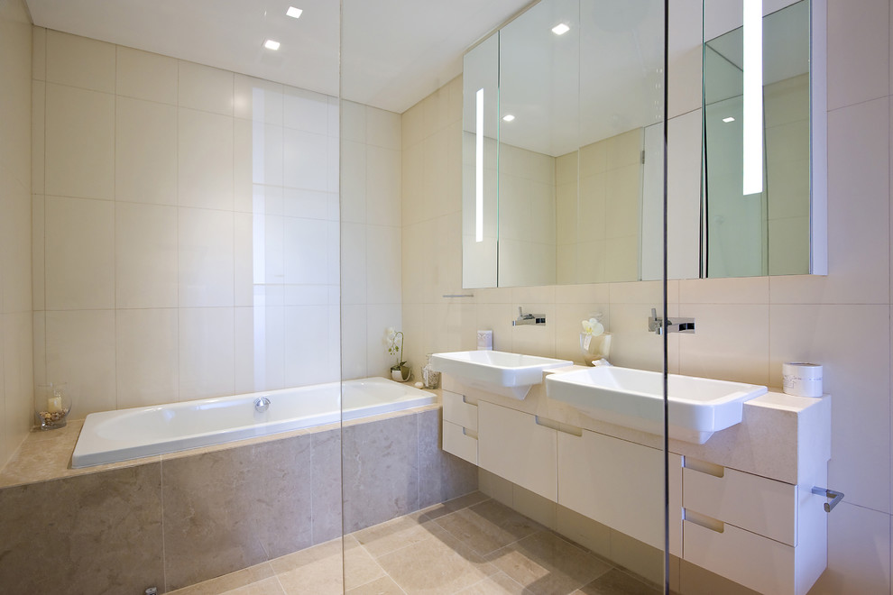 Inspiration for a contemporary master bathroom in Other with beige cabinets, a drop-in tub, beige tile, ceramic tile, beige walls, ceramic floors, beige floor, beige benchtops, a double vanity and a floating vanity.