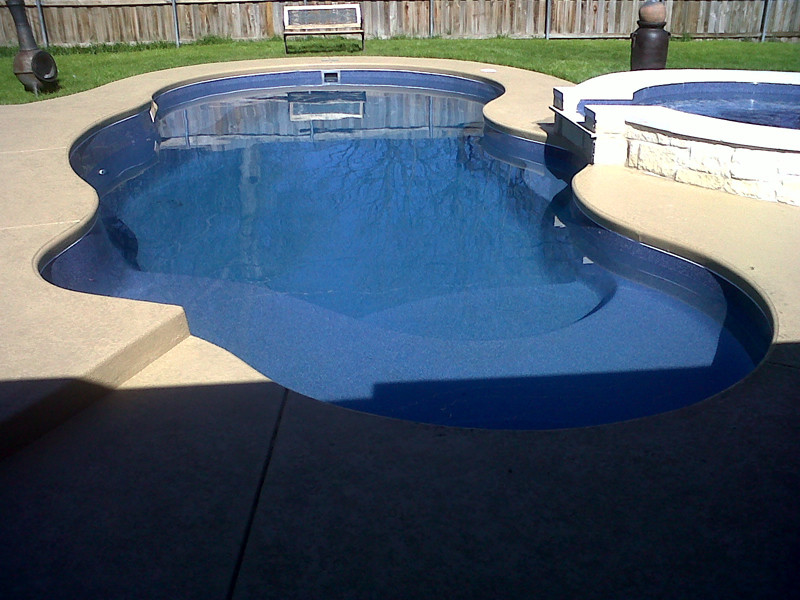 Backyard stone and custom-shaped pool fountain photo