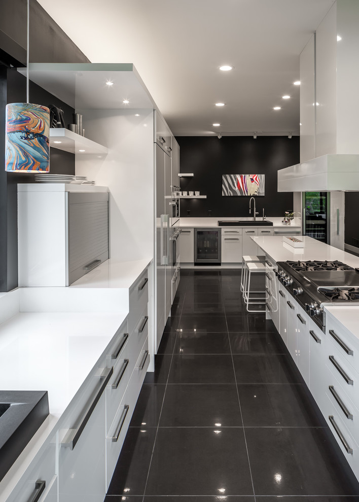 Expansive contemporary galley open plan kitchen in Minneapolis with flat-panel cabinets, white cabinets, with island, a single-bowl sink, quartz benchtops, white splashback, white appliances and porcelain floors.