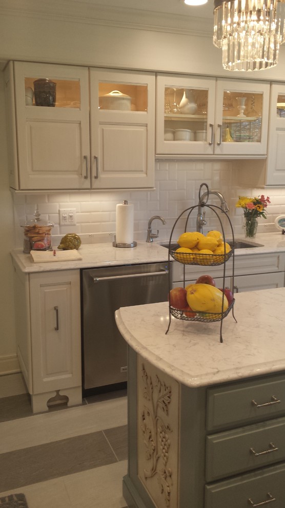 Eat-in kitchen - small transitional u-shaped ceramic tile eat-in kitchen idea with an undermount sink, raised-panel cabinets, white cabinets, marble countertops, white backsplash, subway tile backsplash, stainless steel appliances and an island