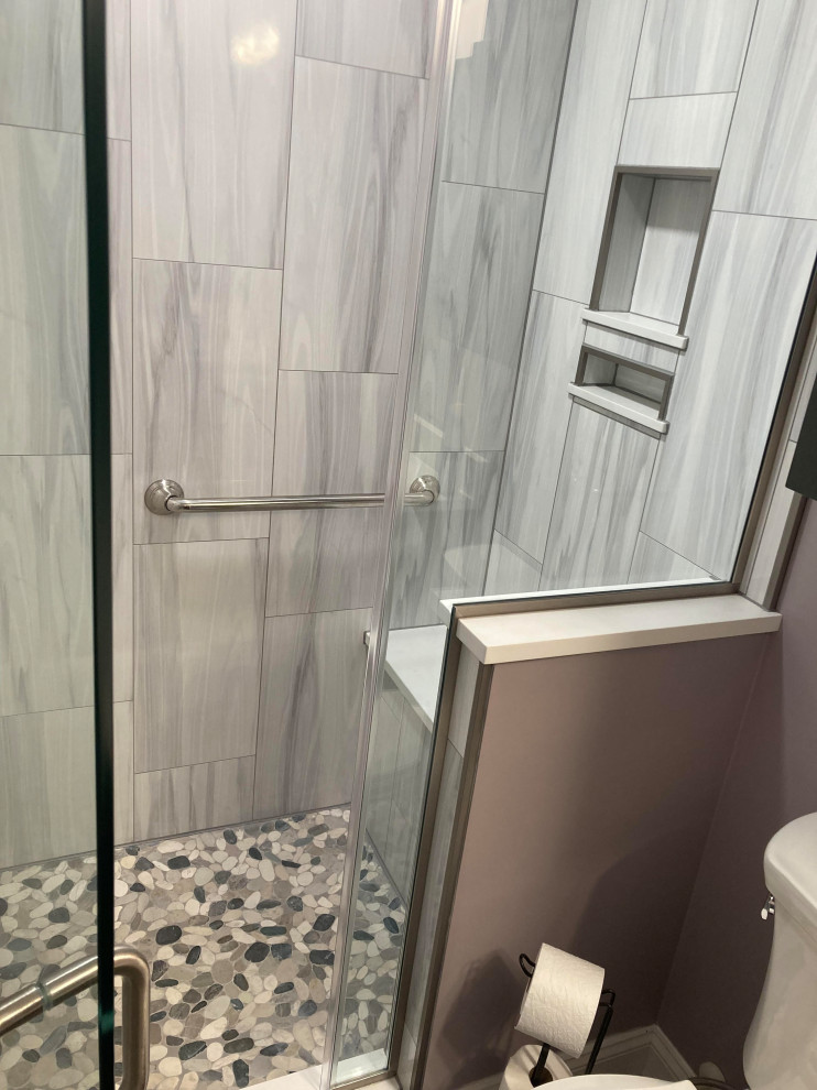 Transitional bathroom in Baltimore with a two-piece toilet, white tile, ceramic tile, grey walls, beige floor, a hinged shower door and a shower seat.