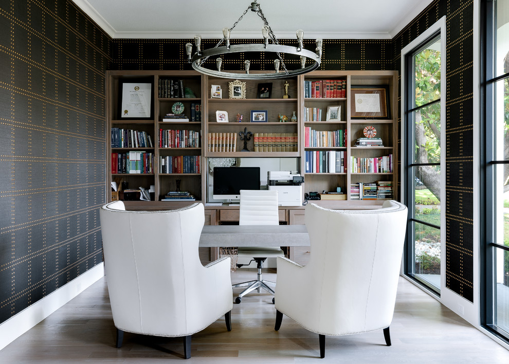 Mediterranean home office in Dallas with a library, multi-coloured walls, light hardwood floors, no fireplace, a freestanding desk and beige floor.