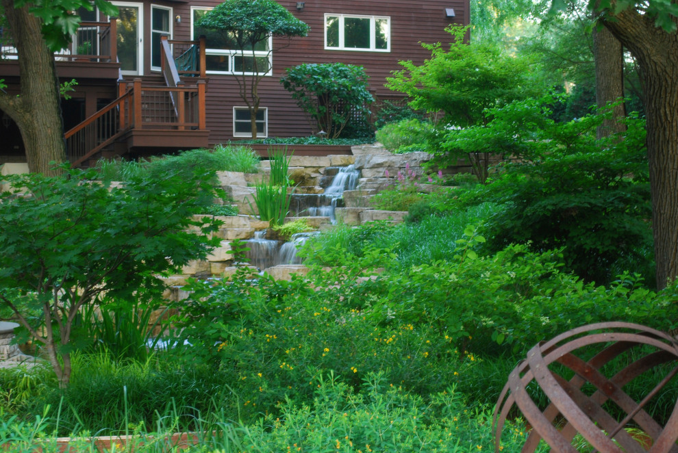 Photo of a large transitional partial sun backyard stone landscaping in Chicago for summer.