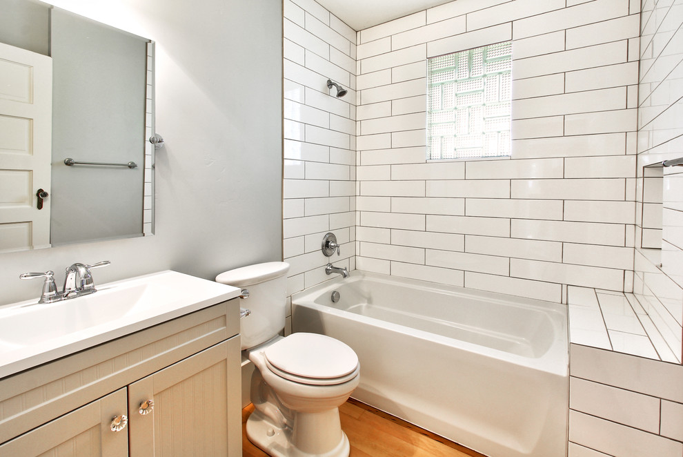Photo of a small modern bathroom in Boise with white tile, subway tile and medium hardwood floors.