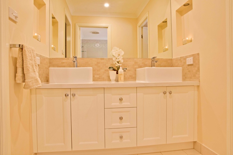 This is an example of an expansive transitional master bathroom in Sydney with furniture-like cabinets, white cabinets, a freestanding tub, an open shower, porcelain tile and porcelain floors.
