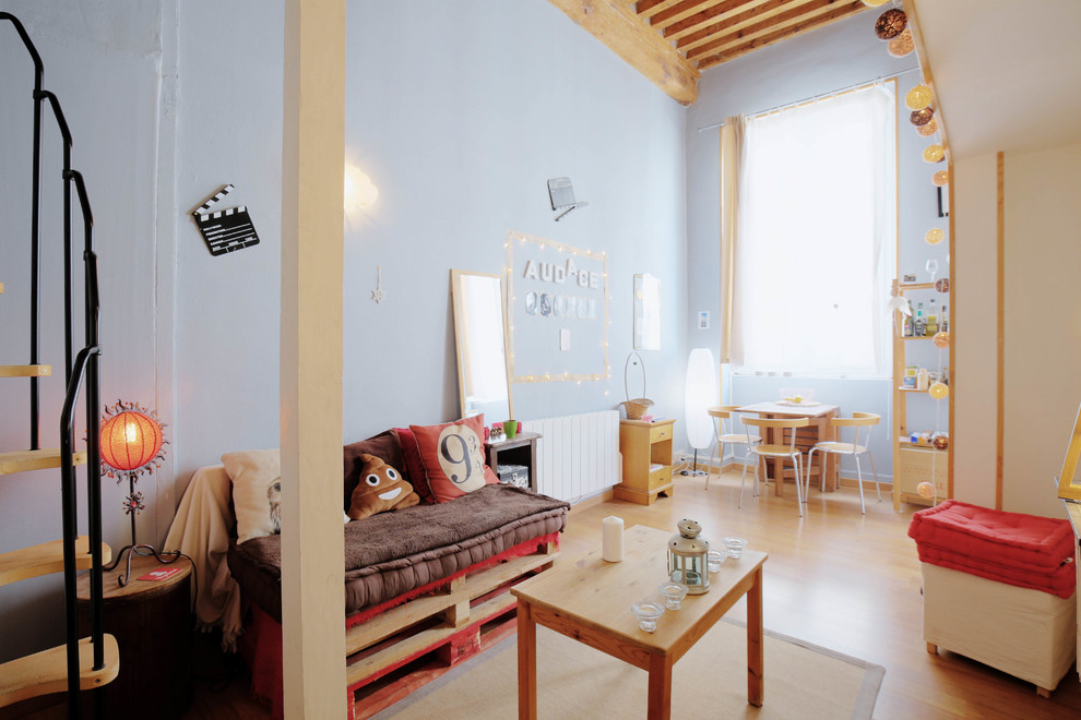 Photo of an industrial gender-neutral kids' playroom for kids 4-10 years old in Lyon with blue walls, medium hardwood floors and brown floor.