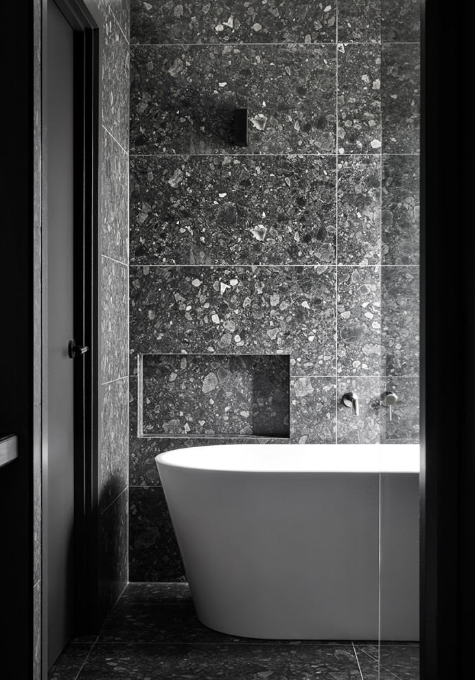 Großes Modernes Badezimmer mit freistehender Badewanne, schwarzen Fliesen, Marmorfliesen, schwarzer Wandfarbe, Marmorboden, schwarzem Boden und Wandnische