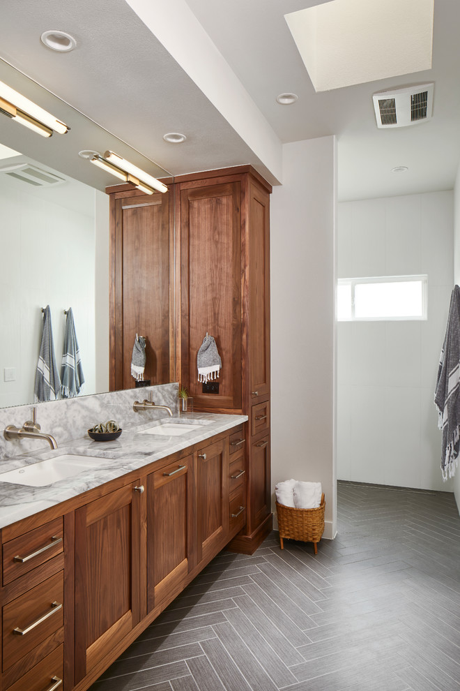 Example of a mid-sized transitional master gray tile gray floor bathroom design in Austin with shaker cabinets, medium tone wood cabinets, white walls, quartzite countertops, an undermount sink and gray countertops