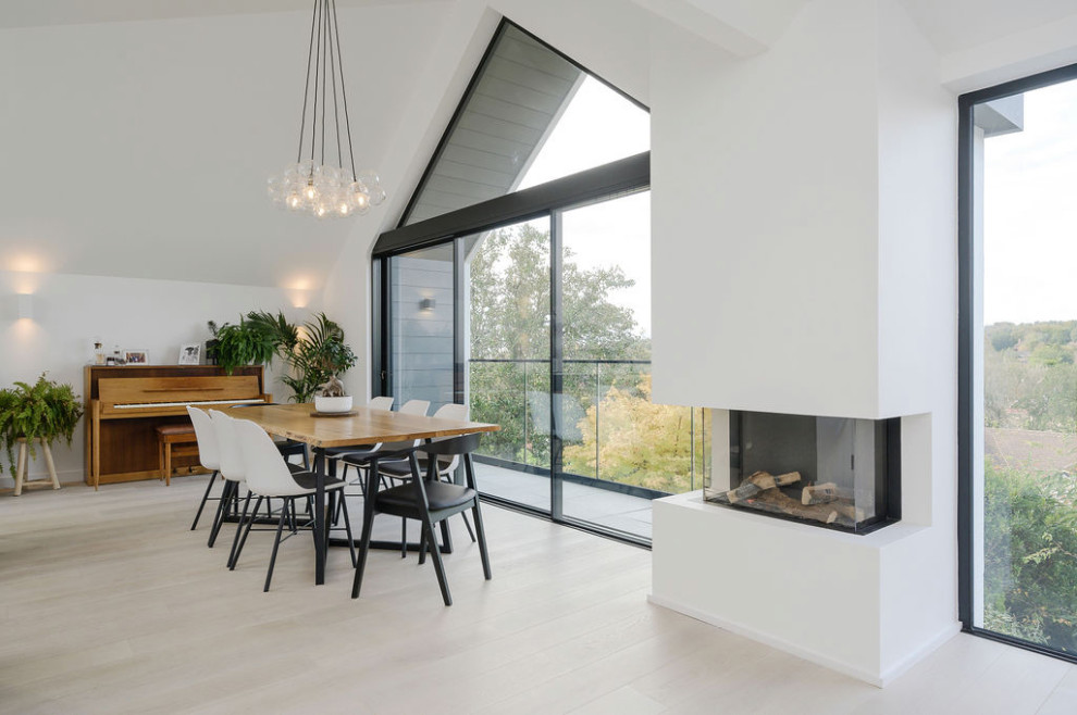 Photo of a large contemporary open plan dining with white walls, light hardwood floors and vaulted.