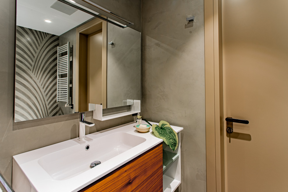 Idéer för ett mellanstort modernt vit badrum, med skåp i mellenmörkt trä, ett badkar i en alkov, en dusch/badkar-kombination, en vägghängd toalettstol, grå väggar, betonggolv, ett väggmonterat handfat, bänkskiva i akrylsten, grått golv och dusch med skjutdörr