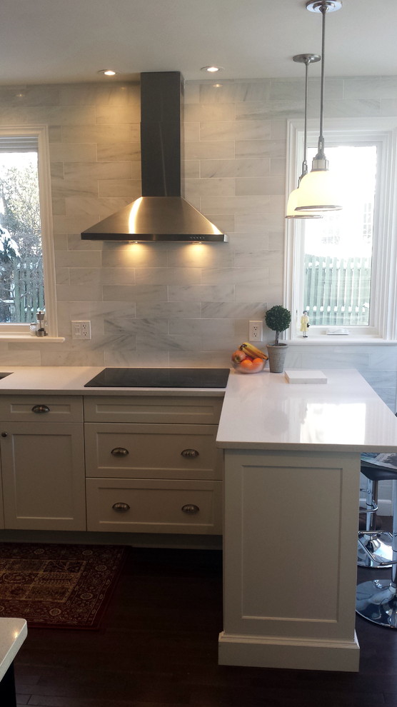 Inspiration for a mid-sized transitional u-shaped dark wood floor enclosed kitchen remodel in Ottawa with an undermount sink, shaker cabinets, white cabinets, quartz countertops, white backsplash, subway tile backsplash, stainless steel appliances and a peninsula