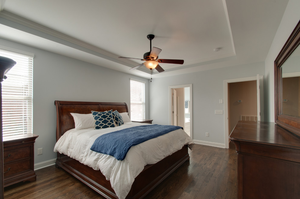 This is an example of a mid-sized country master bedroom in Nashville with dark hardwood floors, brown floor and grey walls.