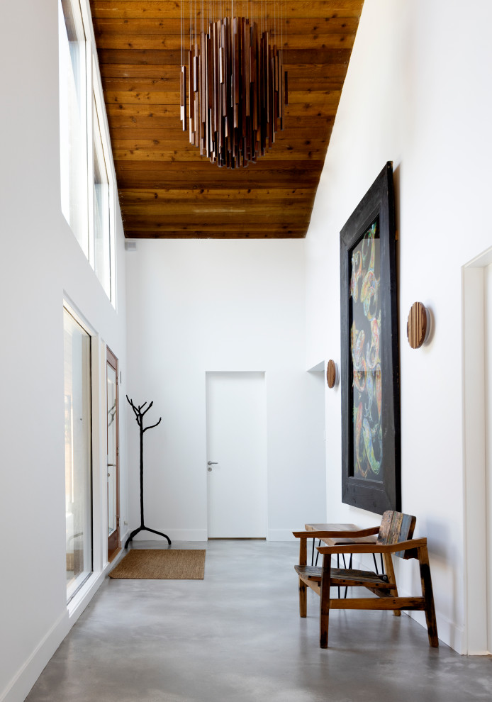 Стильный дизайн: коридор в стиле лофт с белыми стенами, бетонным полом, серым полом, сводчатым потолком и деревянным потолком - последний тренд