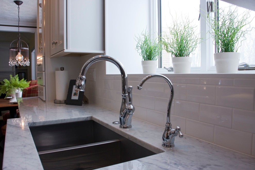 Kitchen - transitional kitchen idea with white cabinets, marble countertops and stainless steel appliances
