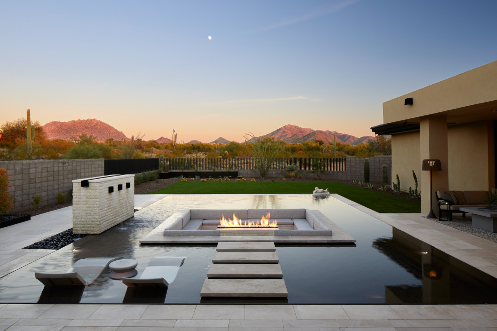Inspiration for a mid-sized backyard rectangular infinity pool in Phoenix with a water feature and tile.