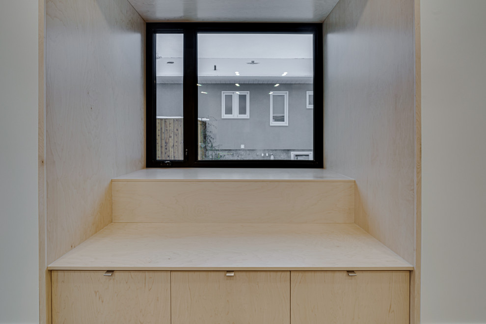 Foto di una cucina moderna di medie dimensioni con lavello sottopiano, ante lisce, ante in legno chiaro, top in quarzite, paraspruzzi verde, elettrodomestici in acciaio inossidabile, pavimento in cemento, pavimento grigio e top bianco