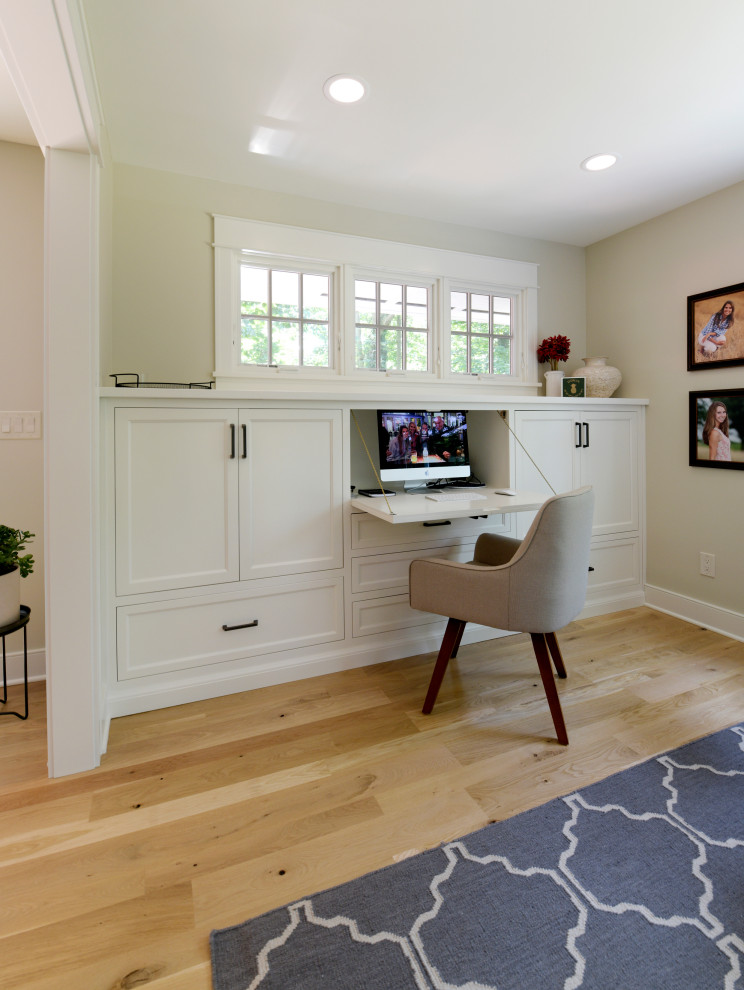 Photo of a mid-sized transitional study room in Columbus with beige walls, light hardwood floors, no fireplace, a built-in desk and beige floor.
