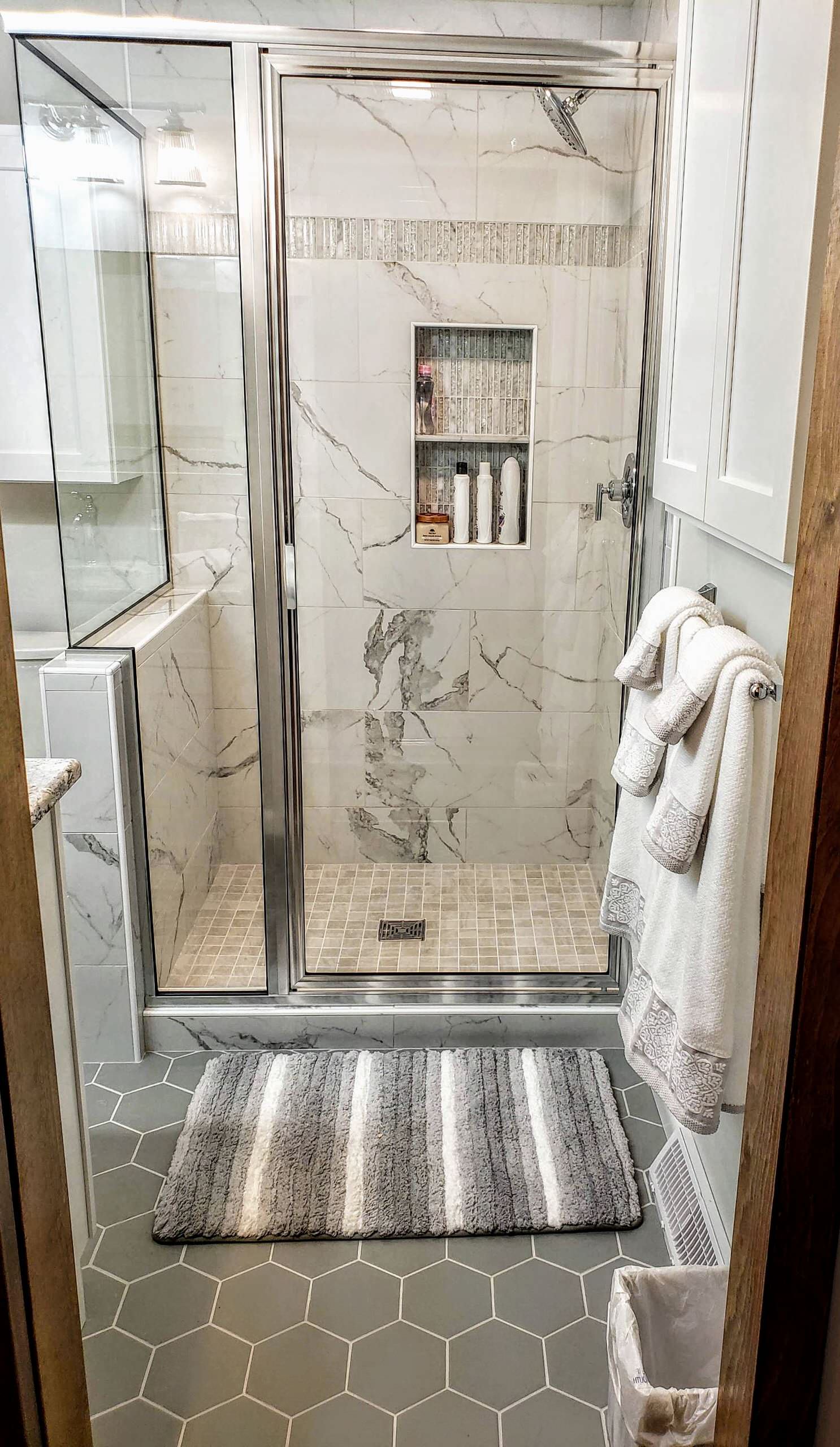Corner shower - small traditional master white tile and porcelain tile porcelain tile and gray floor corner shower idea in New York with recessed-panel cabinets, white cabinets, a two-piece toilet, gr