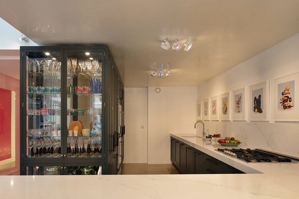 Photo of a large contemporary l-shaped separate kitchen in London with an undermount sink, glass-front cabinets, black cabinets, marble benchtops, a peninsula and white benchtop.