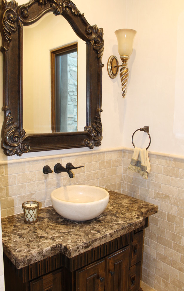 Photo of a small mediterranean 3/4 bathroom in San Luis Obispo with a vessel sink, furniture-like cabinets, dark wood cabinets, marble benchtops, beige tile, stone tile and beige walls.