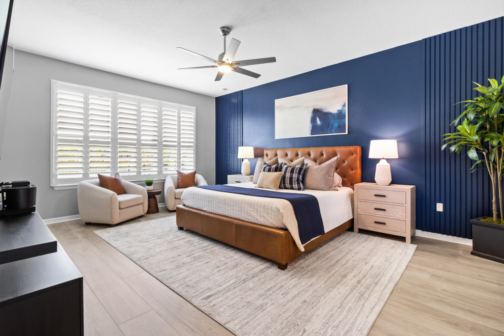 Large contemporary master bedroom in Orlando with blue walls and panelled walls.