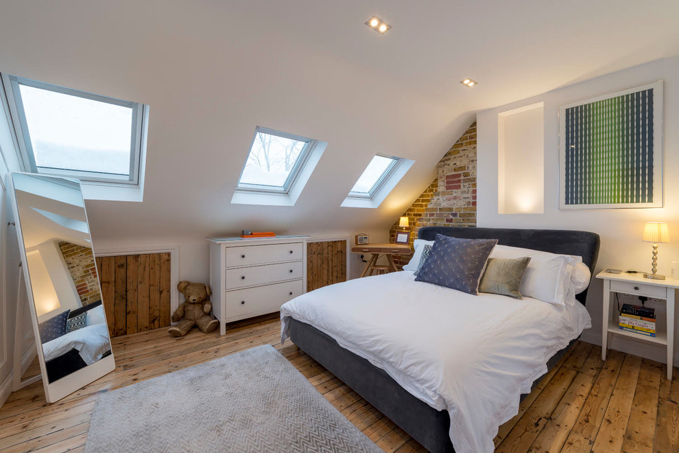 This is an example of a mid-sized contemporary gender-neutral kids' room in London with white walls, medium hardwood floors and brown floor.