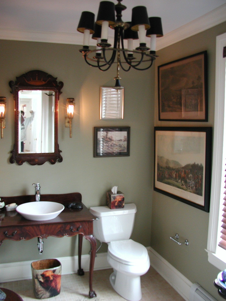 This is an example of a traditional bathroom in New York with a vessel sink, furniture-like cabinets, dark wood cabinets, wood benchtops, a two-piece toilet, beige tile, porcelain tile, green walls and porcelain floors.