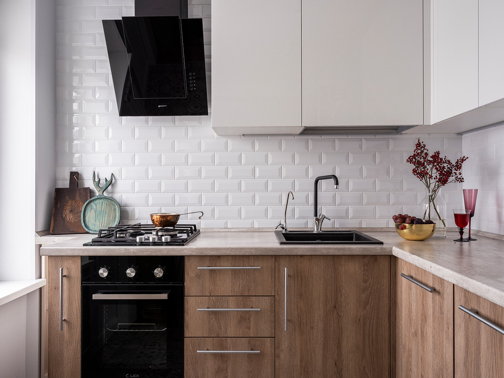 Scandinavian l-shaped separate kitchen in Moscow with a drop-in sink, flat-panel cabinets, medium wood cabinets, white splashback, beige benchtop, black appliances, no island and window splashback.