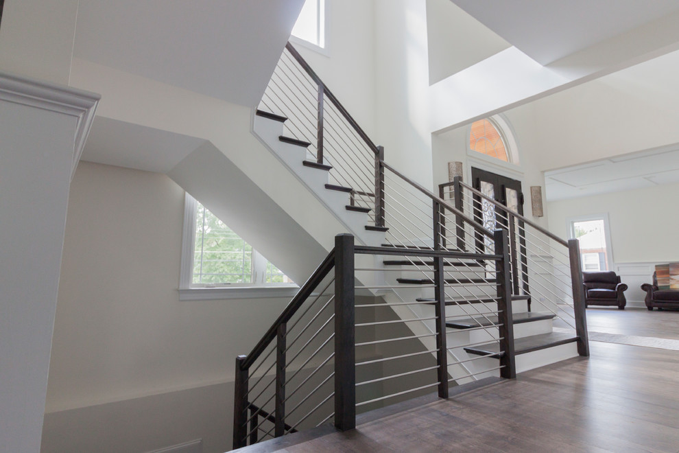 Inspiration for a large transitional wood u-shaped staircase in DC Metro with wood risers and mixed railing.