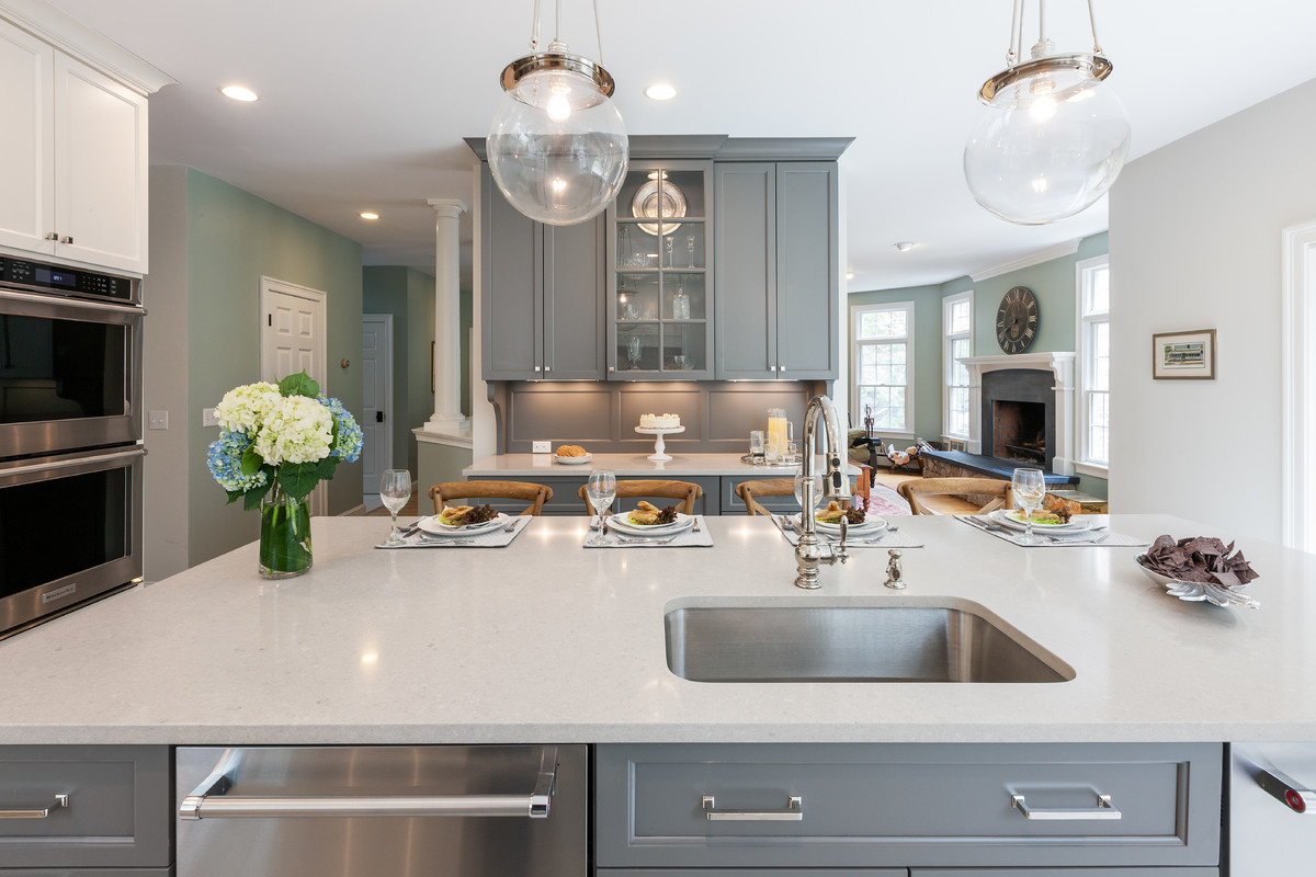 Example of a transitional kitchen design in Boston with an undermount sink, gray cabinets, quartzite countertops, subway tile backsplash, stainless steel appliances and an island