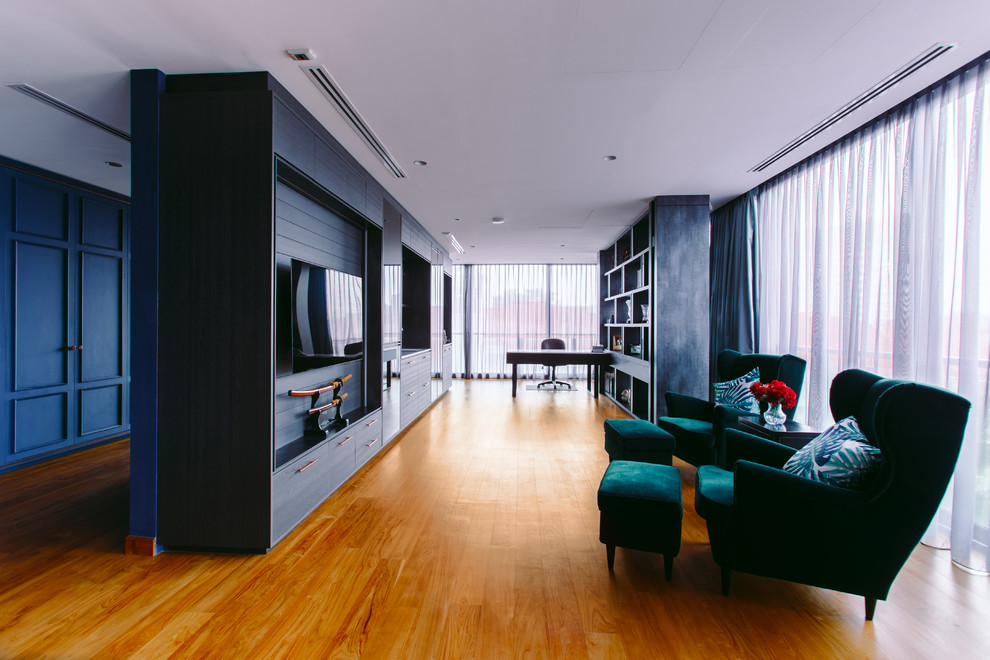 This is an example of a contemporary living room in Singapore with medium hardwood floors, a wall-mounted tv and brown floor.