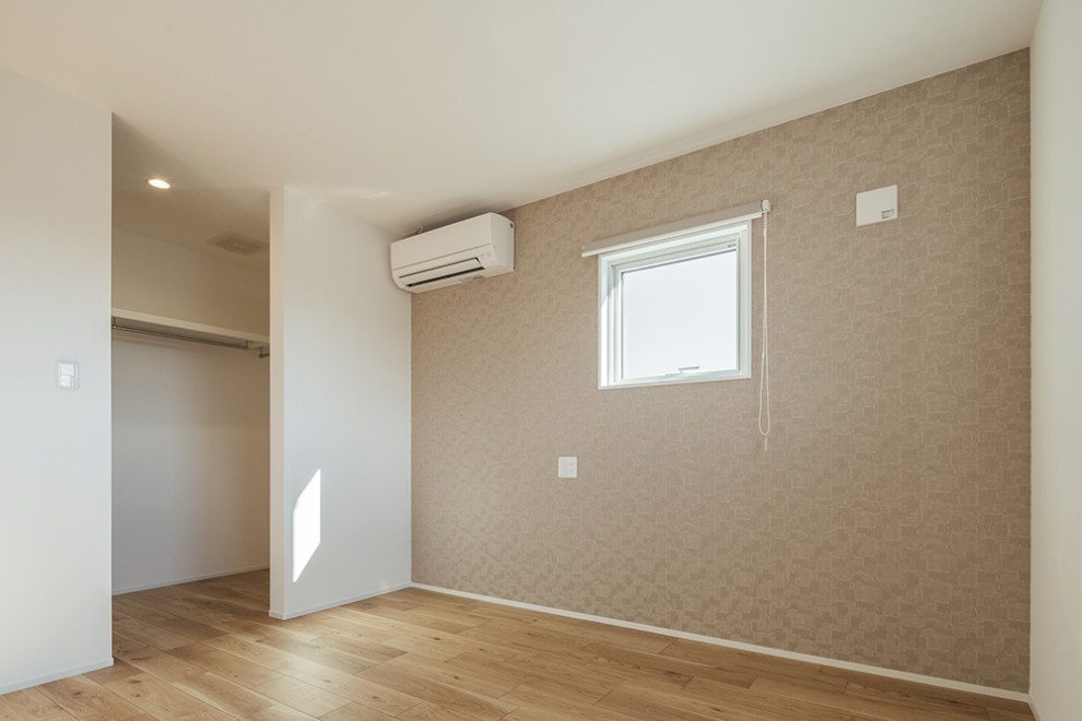 Ejemplo de dormitorio principal y blanco de tamaño medio con paredes marrones, suelo de madera clara, suelo beige, papel pintado y papel pintado
