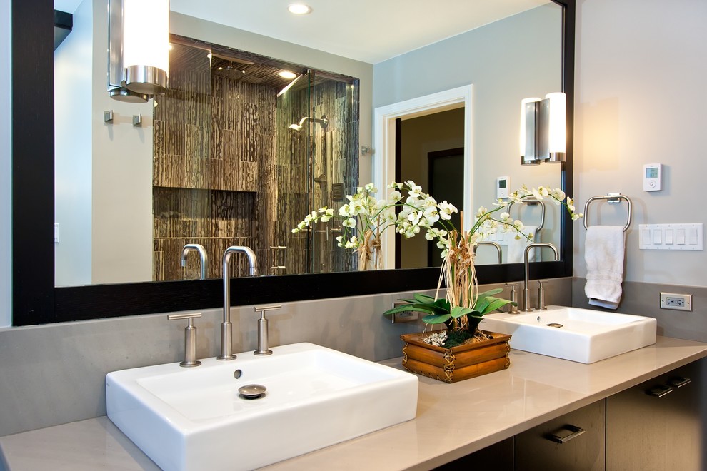 This is an example of a mid-sized modern master bathroom in Chicago with a vessel sink, flat-panel cabinets, dark wood cabinets, engineered quartz benchtops, an alcove shower, multi-coloured tile, stone tile, grey walls and porcelain floors.