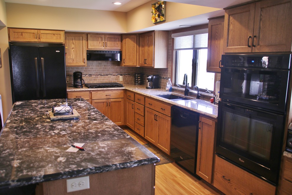 Eat-in kitchen - mid-sized l-shaped eat-in kitchen idea with flat-panel cabinets, medium tone wood cabinets, quartz countertops, beige backsplash, black appliances and an island