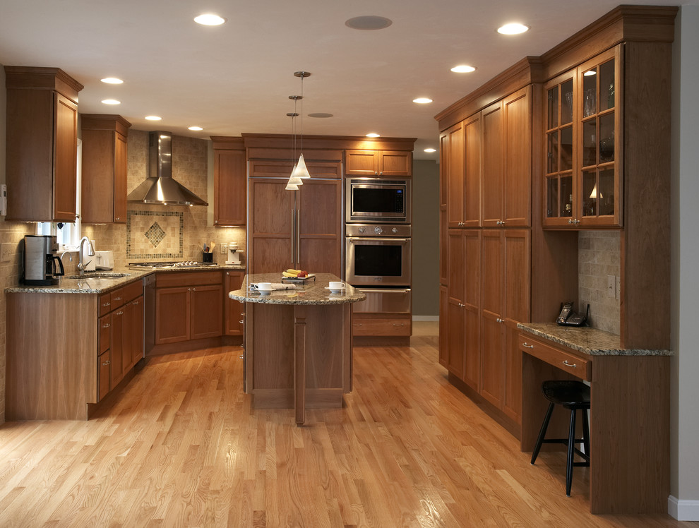Design ideas for a transitional u-shaped separate kitchen in Boston with a drop-in sink, medium wood cabinets, granite benchtops, beige splashback, ceramic splashback, stainless steel appliances, light hardwood floors and with island.