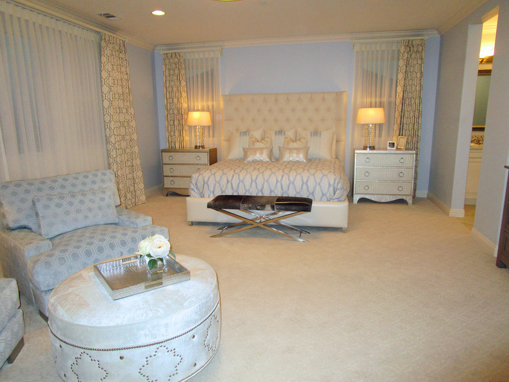This is an example of a large transitional master bedroom in San Diego with blue walls, carpet and no fireplace.