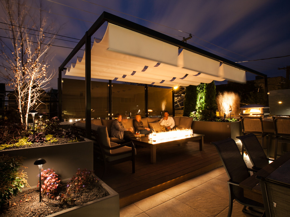 Photo of a mid-sized contemporary rooftop deck in Chicago with a fire feature and a pergola.